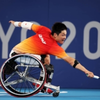 Japan\'s Shingo Kunieda makes a return to China\'s Zhenxu Ji during the third round of  the men\'s singles wheelchair tennis. | REUTERS