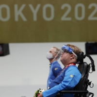 Gold medalist Philip Jonsson of Sweden observes the national anthem during the medal ceremony of the R4 shooting competition of mixed 10-meter air rifle standing SH2. | REUTERS