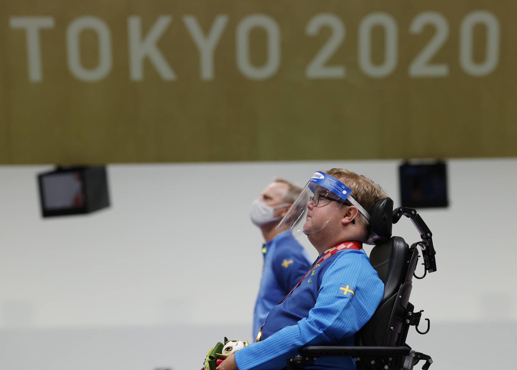 Gold medalist Philip Jonsson of Sweden observes the national anthem during the medal ceremony of the R4 shooting competition of mixed 10-meter air rifle standing SH2. | REUTERS