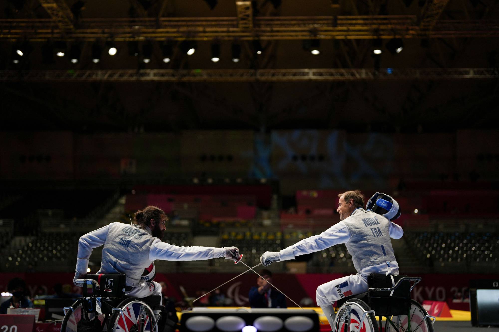 Great Britain's Dimitri Coutya (left) greets France's Romain Noble during the semi-final wheelchair fencing match of men's foil team. | AFP-JIJI
