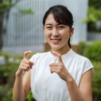 NHK reporter Yuki Goto signs \"hello\" outside Tokyo\'s National Stadium, where the 25-year-old is covering athletic events at the Paralympics. | RYUSEI TAKAHASHI
