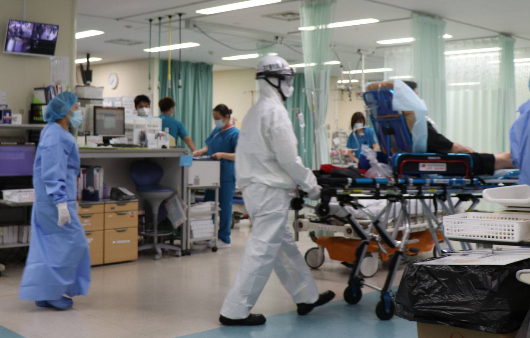 First responders move a COVID-19 patient into Nagoya Ekisaikai Hospital’s Emergency Medical Center in Nagoya in August. | CHUNICHI SHIMBUN