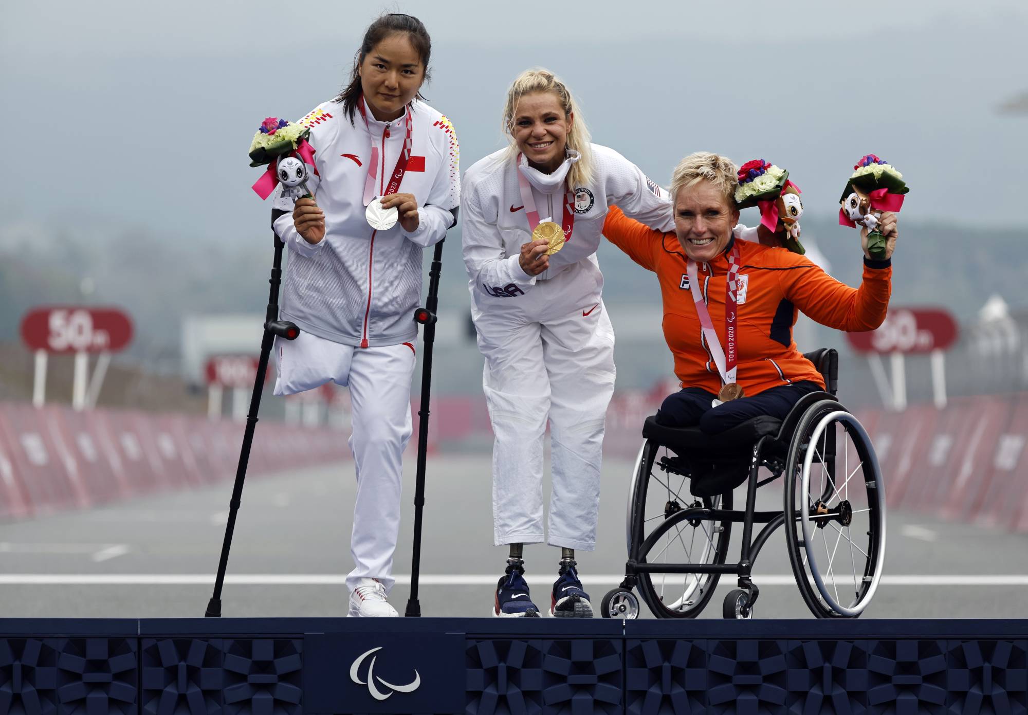 Silver medalist Bianbian Sun of China, gold medalist Oksana Masters of the United States and bronze medalist Jennette Jansen of the Netherlands celebrate during the medal ceremony of the women's H4-5 cycling road time trial | REUTERS