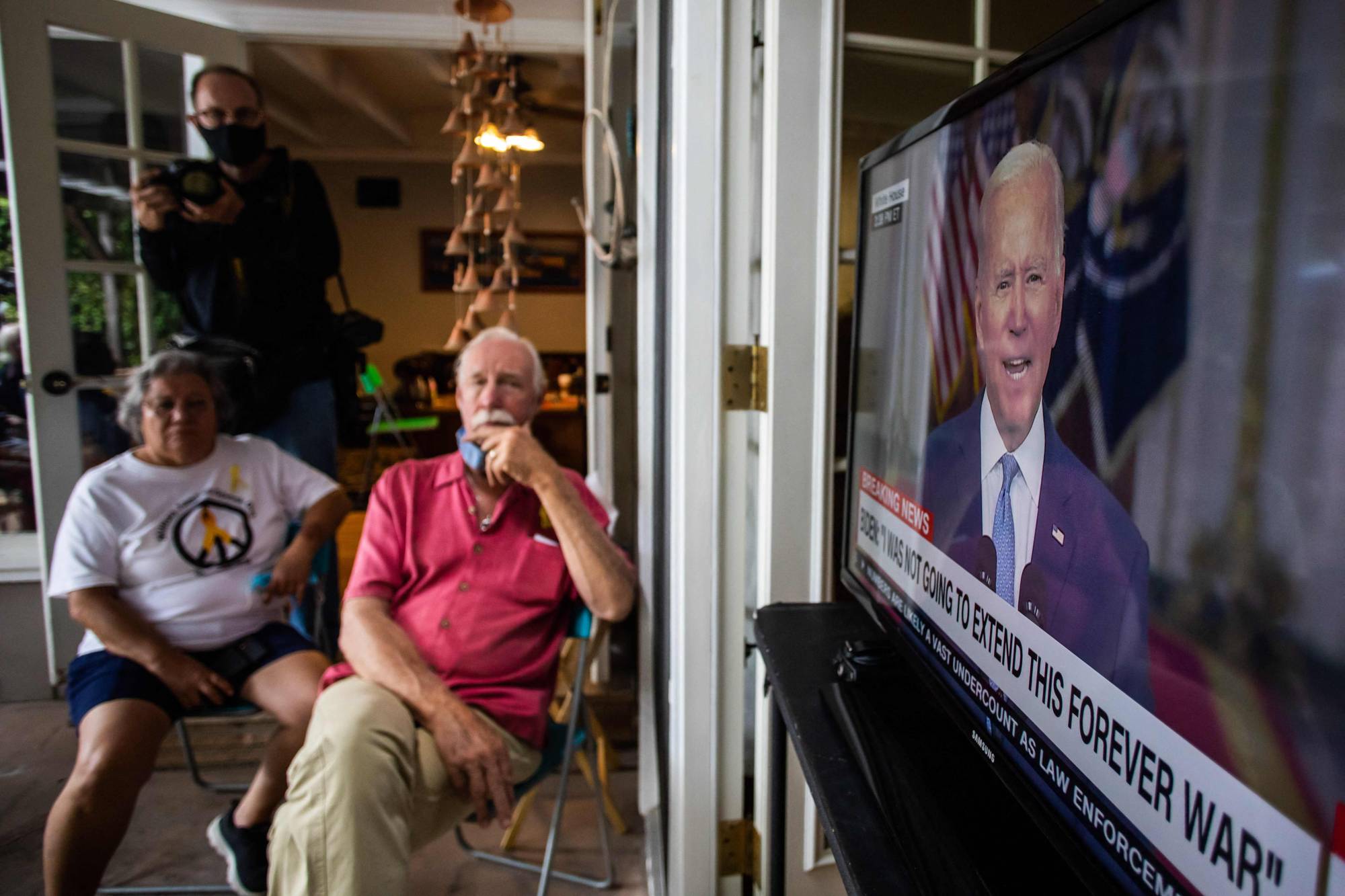 A group of military families and veterans watch U.S. President Joe Biden's speech announcing that all American troops are out of Afghanistan on Tuesday.  | AFP-JIJI
