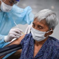 A woman gets a shot of a COVID-19 vaccine in Bangkok in July.  | REUTERS