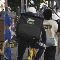 An Uber Eats employee delivers food in Kobe. | KYODO