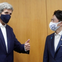 Environment Minister Shinjiro Koizumi meets U.S. climate envoy John Kerry in Tokyo on Tuesday. | POOL / VIA REUTERS
