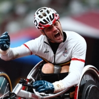 Belgium\'s Peter Genyn celebrates after winning gold and setting a new Paralypmic record in the men\'s 100-meter T51 final on Friday at the Olympic Stadium. | REUTERS
