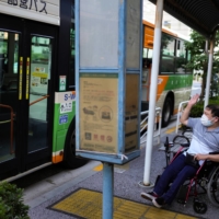 Yuto Hirano, a volunteer for the Paralympics, navigates boarding a bus in Tokyo on Aug. 23. Tokyo has made improvements to its accessibility, but people with disabilities still encounter barriers daily.  | CHANG W. LEE/THE NEW YORK TIMES