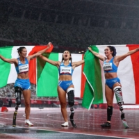 Team Italy celebrates sweeping the top spots in the women\'s T63 100 meters. From left: Monica Graziana Contrafatto (bronze), Ambra Sabatini (gold) and Martina Caironi (silver). Sabatini also broke the world record. | REUTERS
