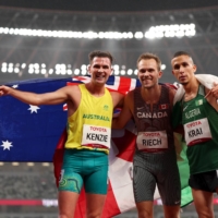 Canada\'s Nate Riech (center) celebrates after winning gold and setting a new Paralympic record in the men\'s T38 1,500 meters, along with silver medalist Abdelkrim Krai of Algeria (right) and bronze medalist Deon Kenzie of Australia. | REUTERS