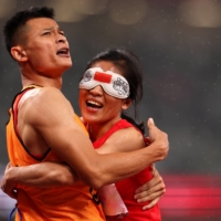 China\'s Cuiqing Liu celebrates with guide Donglin Xu after winning gold in the women\'s T11 200 meters | REUTERS
