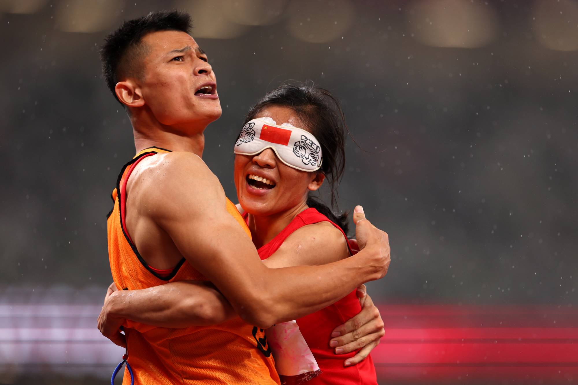 China's Cuiqing Liu celebrates with guide Donglin Xu after winning gold in the women's T11 200 meters | REUTERS