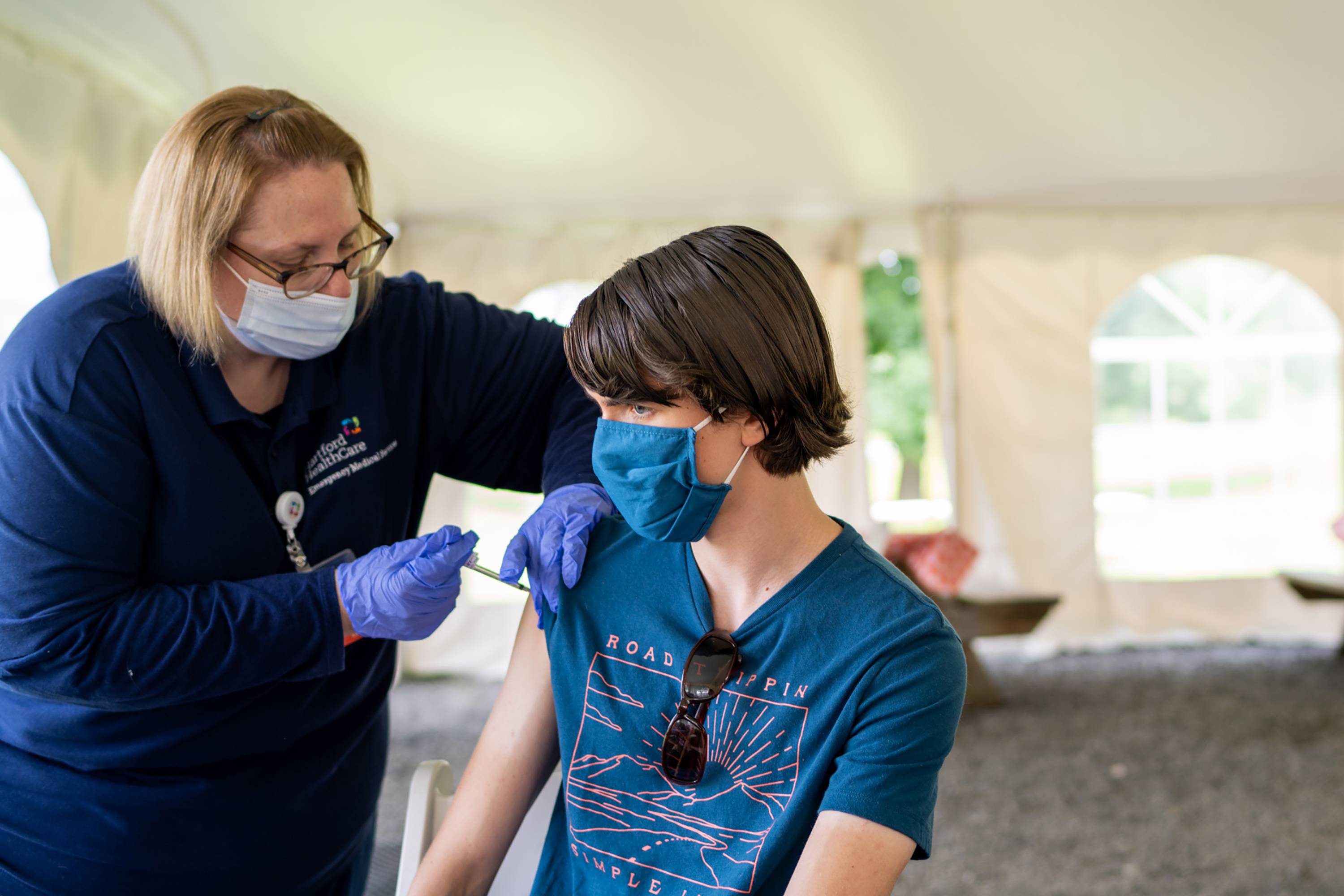 A teenager receives a COVID-19 vaccine at a pop-up clinic in Middlefield, Connecticut. | Christopher Capozziello / The New York Times