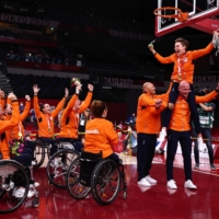 Bo Kramer of the Netherlands cuts the net as she celebrates winning gold with teammates following the medal ceremony for women\'s wheelchair basketball. | REUTERS