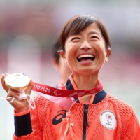 Michishita celebrates with her gold medal on the Olympic Stadium victory podium. | REUTERS