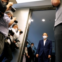 Prime Minister Yoshihide Suga arrives to meet with Andrew Parsons, president of the International Paralympic Committee, in Tokyo on Friday. | POOL / VIA REUTERS