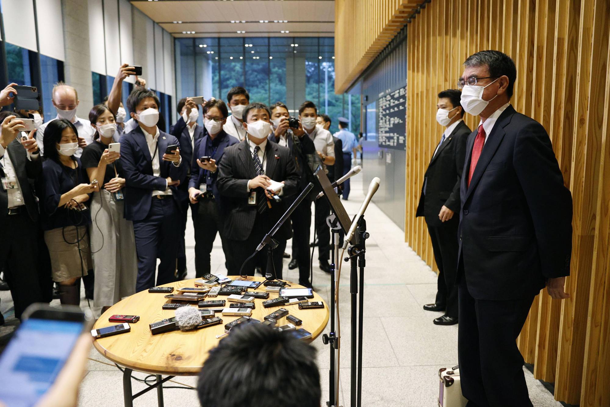Administrative Reform Minister Taro Kono (right) speaks to reporters Friday in Tokyo after Prime Minister Yoshihide Suga said he would not run in the Sept. 29 Liberal Democratic Party leadership election. | KYODO
