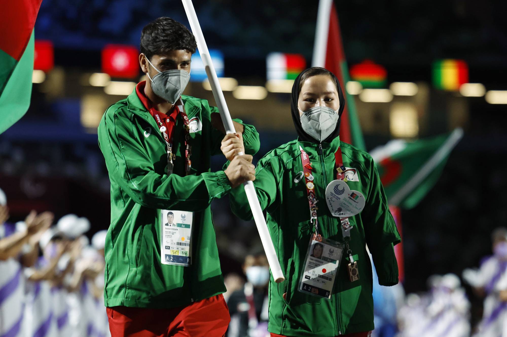 Afghan athletes Hossain Rasouli (left) and Zakia Khudadadi carry their nation's flag into the stadium during the closing ceremony. | REUTERS