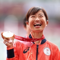 Misato Michishita celebrates on the podium after winning gold in the women\'s T12 marathon at the 2020 Tokyo Paralympics on Sunday. | REUTERS