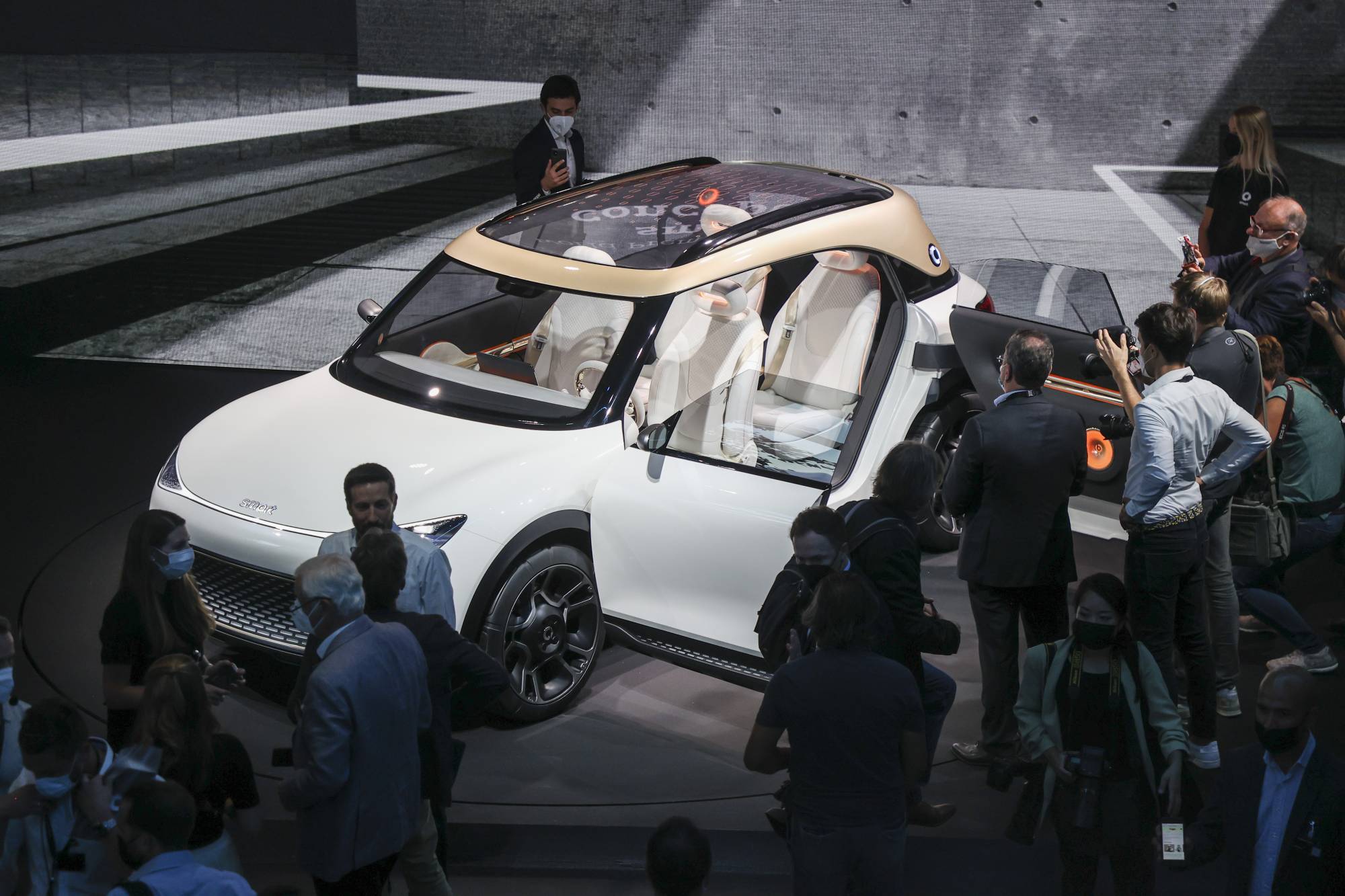 Attendees view the Daimler AG Smart Concept One electric sports utility vehicle, displayed during an unveiling event ahead of the IAA Munich Motor Show in Munich on Sunday. | BLOOMBERG 