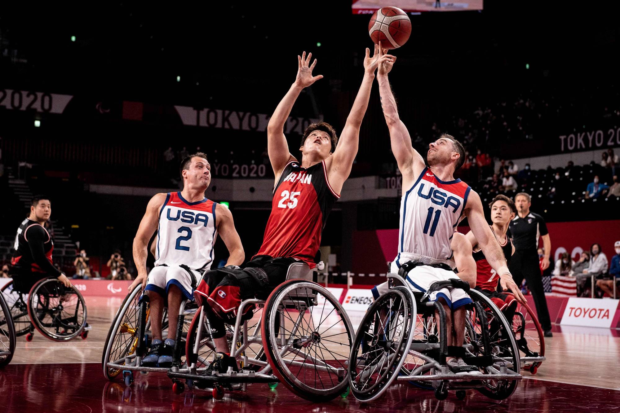 USA's Steve Serio (right) and Japan's Kei Akita (center) reach for the ball in the wheelchair basketball men's final match. | AFP-JIJI