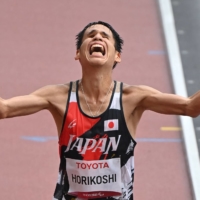 Japan\'s Tadashi Horikoshi crosses the finish line in third place in the men\'s T12 marathon. | AFP-JIJI