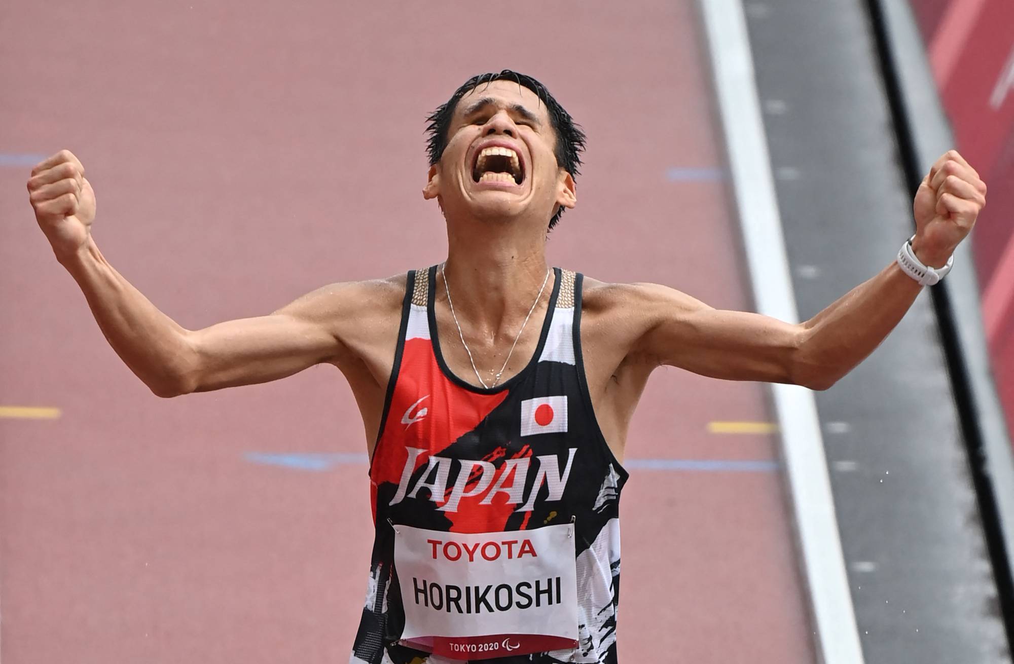 Japan's Tadashi Horikoshi crosses the finish line in third place in the men's T12 marathon. | AFP-JIJI
