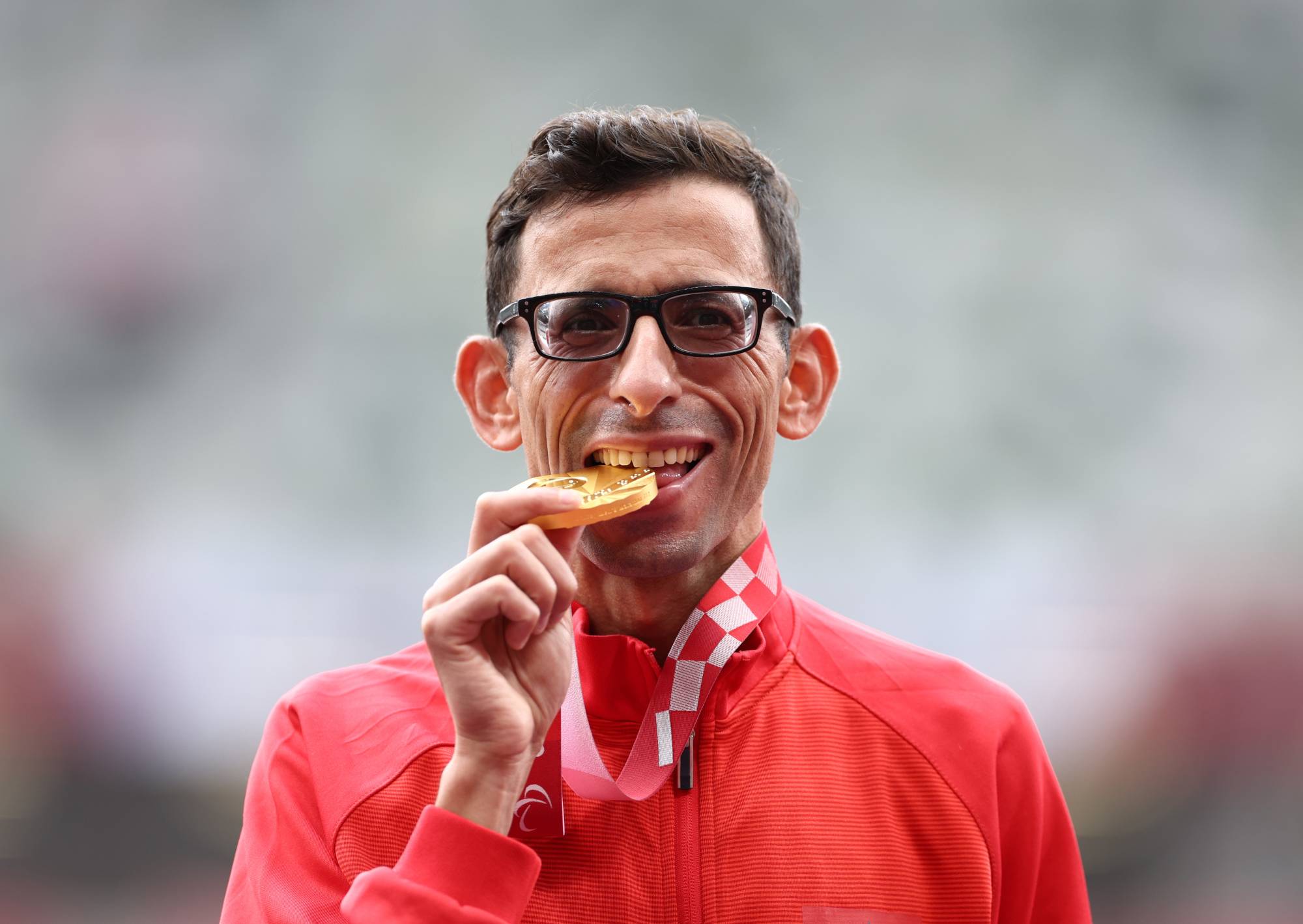 Morocco's gold medalist of men's T12 marathon El Amin Chentouf celebrates on the podium in the medal ceremony. | REUTERS