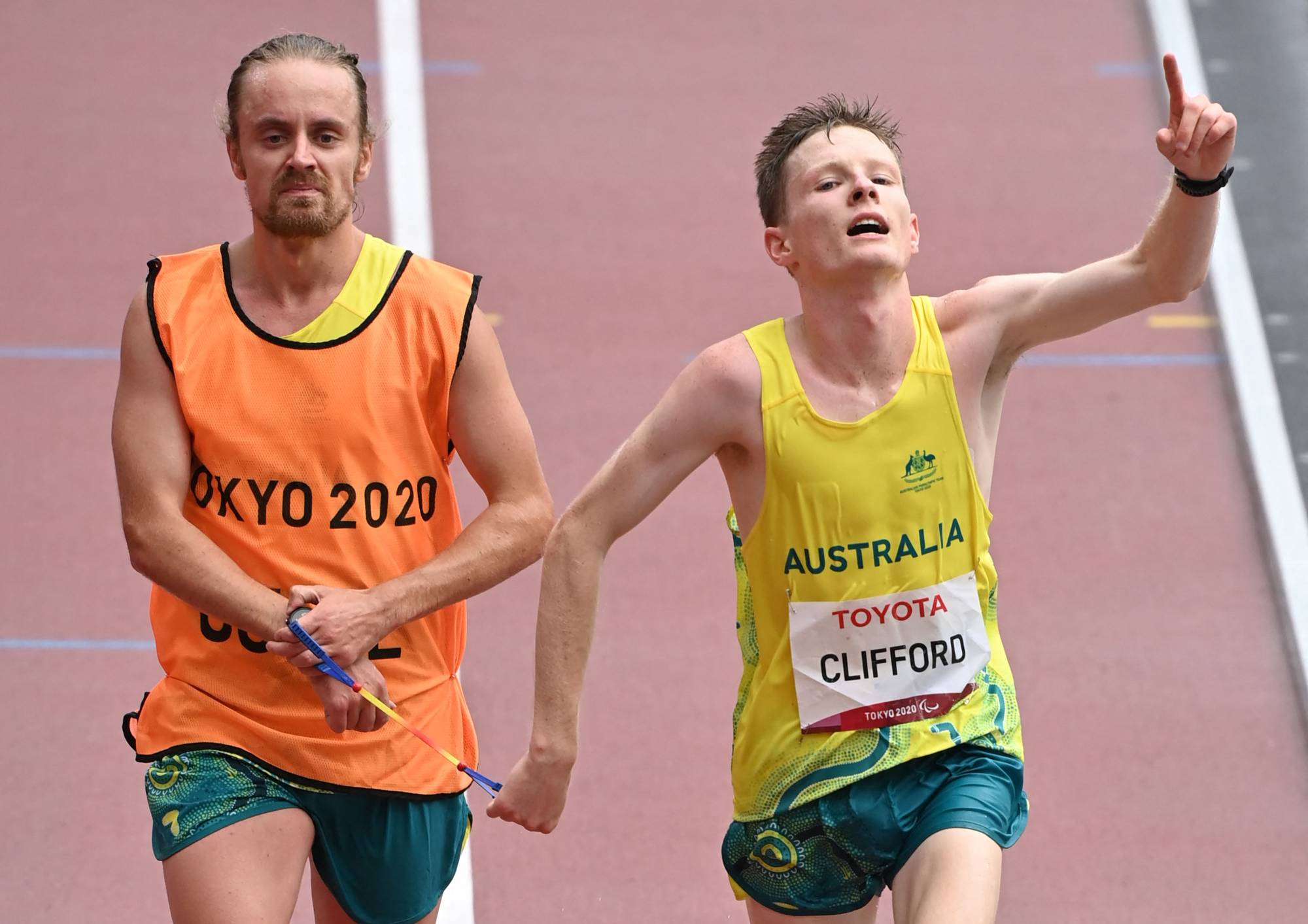 Australia's Jaryd Clifford (right) and his guide cross the finish line to win the men's T12 marathon. | AFP-JIJI