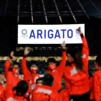 Japan athletes wave as \"Thank you\" in Japanese is displayed in the National Stadium | REUTERS