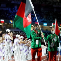 Afghanistan\'s Hossain Rasouli and Zakia Khudadadi carry their nation\'s flag | REUTERS