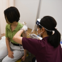 A health care worker administers a dose of the Moderna Inc. Covid-19 vaccine in the city of Saitama last month. | BLOOMBERG