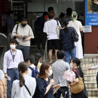 People go to a vaccination center for the young in Tokyo\'s Shibuya Ward last month. | KYODO