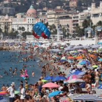 Sun-worshippers throng the Promenade des Anglais in the French Riviera city of Nice last month. | AFP-JIJI