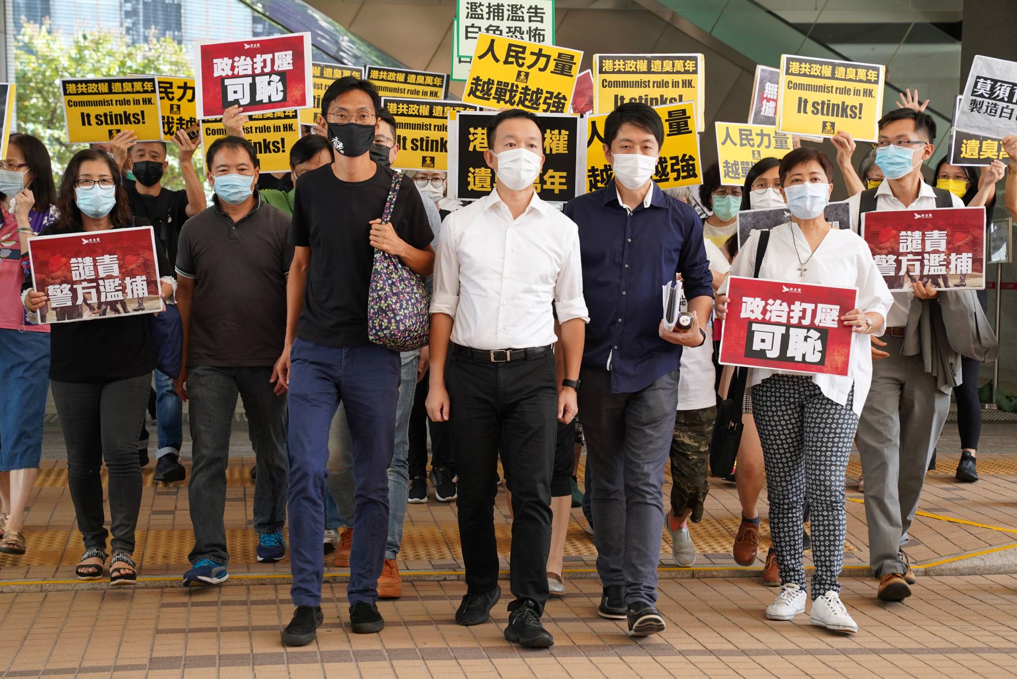 Former pro-democracy lawmakers Ted Hui Chi-fung, Raymond Chan Chi-chuen and Eddie Chu Hoi-dick appear outside Hong Kong's West Kowloon Magistrates' Courts.  | REUTERS