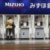 Mizuho Bank ATMs are inoperable in March. A system failure affecting around 100 ATMs at the bank Wednesday morning was the seventh such disruption of its services this year. | KYODO