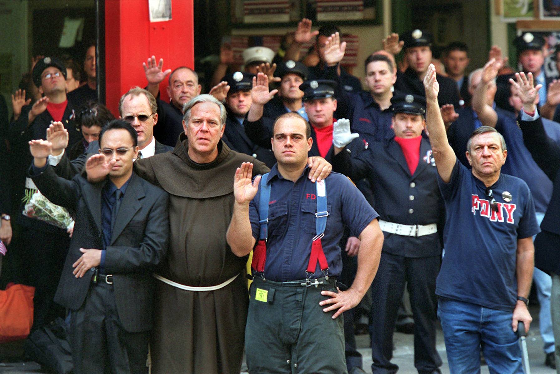 Father Michael Duffy leads firefighters in a benediction for Father Mychal Judge, the New York Fire Department chaplain, during the funeral for Judge in New York on Sept. 15, 2001. Judge died on Sept. 11, 2001, while administering last rites at the World Trade Center. | Suzanne DeChillo / The New York Times
