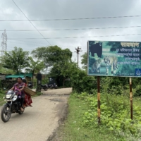 A signboard cautions residents to stay alert to wildlife movement outside Khairgaon village in Chandrapur, India, in August. | THOMSON REUTERS FOUNDATION