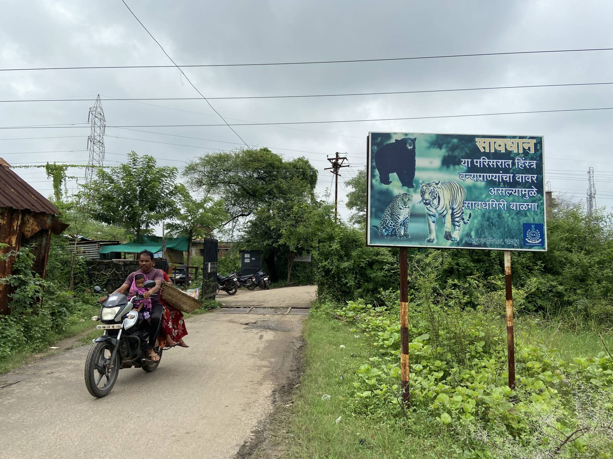 A signboard cautions residents to stay alert to wildlife movement outside Khairgaon village in Chandrapur, India, in August. | THOMSON REUTERS FOUNDATION