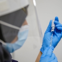 A worker prepares a dose of the AstraZeneca COVID-19 vaccine in London in March.  | BLOOMBERG 