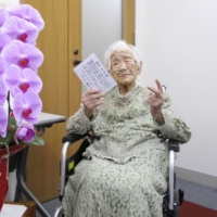 Kane Tanaka, the oldest person in Japan and the world at age 118, poses for a photo in the city of Fukuoka on Monday. | FUKUOKA PREFECTURE / VIA KYODO