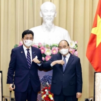 Vietnam\'s President Nguyen Xuan Phuc (R) bumping elbows to greet Japan\'s Defence Minister Nobuo Kishi during a meeting in Hanoi on Sunday. | VIETNAM NEWS AGENCY / AFP-JIJI