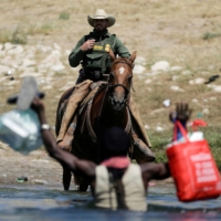 A U.S. border patrol officer cuts the way of a migrant asylum-seeker as he is trying to return to the United States along the Rio Grande river, after having crossed into Mexico to buy food, as seen from Ciudad Acuna, Mexico, on Sunday.  | REUTERS 
