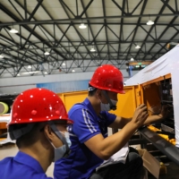 Employees work on assembling an automated guided vehicle at a Lanyu Robot Co. factory in Tianjin, China, on Sept. 7. | REUTERS