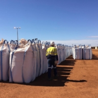 A Lynas worker walks past sacks of rare earth concentrate waiting to be shipped at Mount Weld, northeast of Perth, Australia, in August 2019. | REUTERS