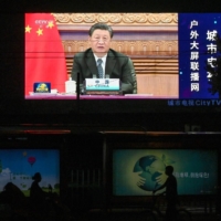 A large screen shows a news program featuring Chinese leader Xi Jinping speaking via video at the opening of the virtual BRICS Summit, on a street in Beijing, on Sept. 10. | AFP-JIJI