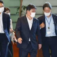 Foreign Minister Toshimitsu Motegi (center) enters the Prime Minister\'s Office on Sept. 15. | KYODO