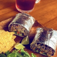Home Taco Bar’s burritos are filled with jasmine rice, black beans, smoked meat and fresh, local lettuce. | © HOME TACO BAR
