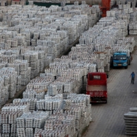 A worker walks through an aluminum ingots depot in Wuxi, China, on Sunday. | REUTERS